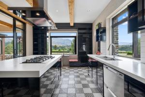 a kitchen with white countertops and a large window at Maunga View in Queenstown +7 photos