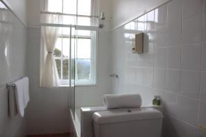 bagno bianco con servizi igienici e finestra di Sponars Chalet a Perisher Valley