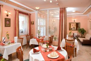 a restaurant with tables and chairs and a couch at Hotel Isabell Győr in Győr