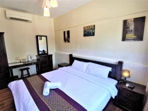 a bedroom with a large white bed with white sheets at 8 Boutique By The Sea in George Town