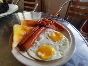 a plate of breakfast food with eggs sausage and toast at 8 Boutique By The Sea in George Town