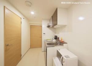 a small kitchen with a sink and a washing machine at Ocean OTR Park View Bentencho in Osaka