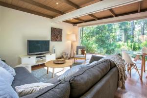 a living room with a couch and a tv at Fernview on Falls in Kalorama