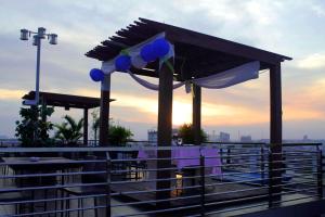 einen Pavillon auf einem Dach mit Sonnenuntergang im Hintergrund in der Unterkunft Transera Hotel Pontianak in Pontianak