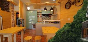 a kitchen with two tables and a clock on the wall at Tobe Home in Luodong