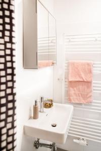 a white bathroom with a sink and a mirror at Twin Apartment in Vienna