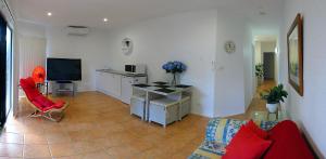 een woonkamer met een bank en een tafel met een tv bij Corlette Retreat in Corlette