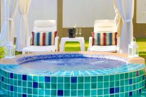 una piscina con 2 sillas y una mesa con en Tortuga Villas Pattaya en Pattaya South