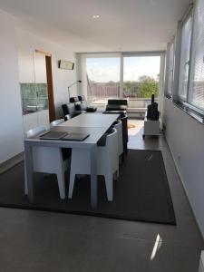 a dining room with a white table and chairs at Residentie Kapelhof in Koksijde
