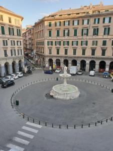 een fontein in het midden van een straat met gebouwen bij Ricci Rooms in Genua