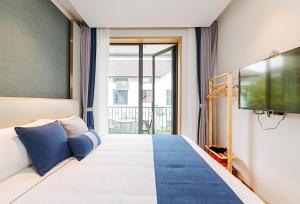 a hotel room with a bed and a tv at Hangzhou Ziwei Boutique Homestay in Hangzhou
