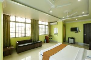 a bedroom with a bed and a couch and a tv at Hotel Grand Luit in Guwahati