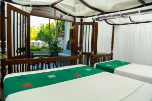 2 bedden in een kamer met een balkon bij Goyambokka Guesthouse in Tangalle