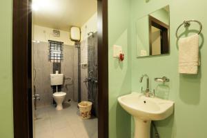 a bathroom with a sink and a toilet at Hotel Grand Luit in Guwahati +35 photos