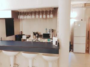 a kitchen with a bar with wine glasses on the wall at Thalassa Beach and Pool Villa in Yoron