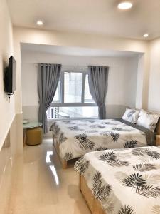 um quarto com 2 camas e uma janela em Hoang Vu Guest House em Da Lat