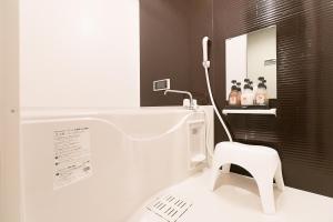 baño con aseo blanco y taburete blanco en Stay SAKURA Kyoto Shijo Karasuma en Kioto