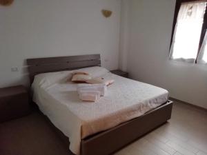 1 dormitorio con 1 cama con 2 toallas en B&B Nino, en Olbia