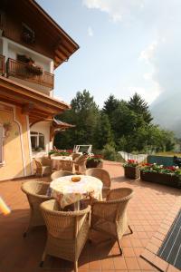 a patio with a table and chairs on a patio at Hotel des Alpes in Molveno
