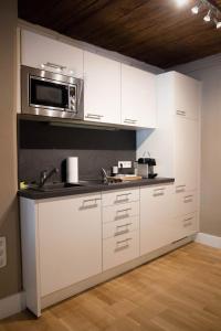 a kitchen with white cabinets and a microwave at Judengasse in Salzburg