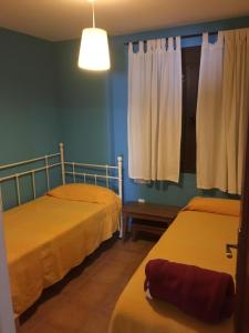 two beds in a room with blue walls at Apartamentos Turisticos Rurales El Pua in Cazalla de la Sierra