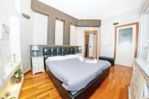 1 dormitorio con 1 cama grande y cabecero negro en The sea from the hills, en Casarza Ligure