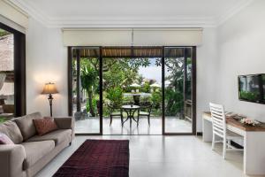 a living room with a couch and a table at Villa Pantai Karang in Sanur
