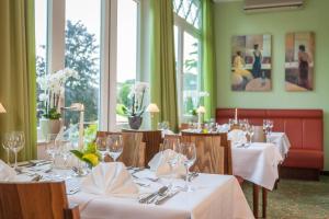 une salle à manger avec des tables et des nappes blanches dans l'établissement Hotel Noltmann-Peters, à Bad Rothenfelde