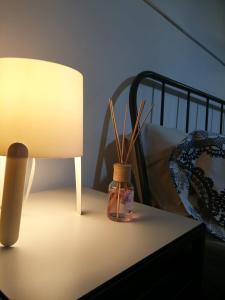 een tafel met een lamp en een fles met een plant erin bij B&B Piccolo Loft del Borgo in Lanciano