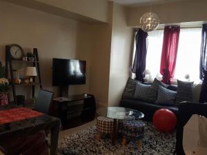a living room with a couch and a tv at Patrick s Place in Davao City