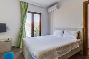 a bedroom with a bed and a window at Mima Apartments in Sveti Stefan