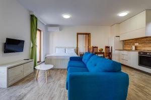un soggiorno con divano blu e letto di Mima Apartments a Sveti Stefan