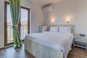 a bedroom with a large bed and a large window at Mima Apartments in Sveti Stefan