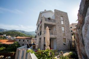 un edificio con ombrellone sul balcone di Mima Apartments a Sveti Stefan