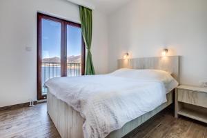 a bedroom with a bed and a large window at Mima Apartments in Sveti Stefan