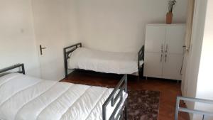 a room with two beds and a cabinet in it at Edelweiss Hostel in Štip