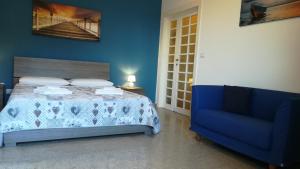 niebieska sypialnia z łóżkiem i niebieską kanapą w obiekcie Bed Cafe w Syrakuzach
