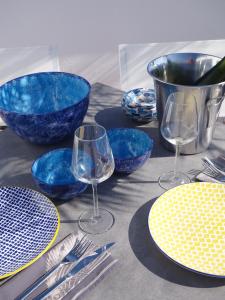 a table with blue bowls and wine glasses on it at Stadthaus Petronella Meerblick und Dachterrasse in Conil de la Frontera