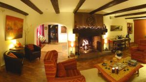 sala de estar con chimenea y sala de estar con sofás en La Haute Grange Gîtes de Charme en Alsace, en Fréland