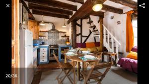 Una cocina con una mesa de madera y un refrigerador. en La Bella Sombra, en Mareny Barraquetas