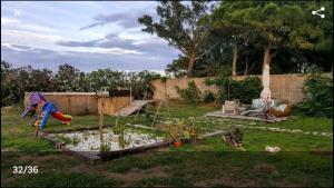 Un patio trasero con un jardín con un estanque con plantas. en La Bella Sombra, en Mareny Barraquetas
