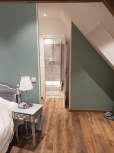 a bedroom with a bed and a table with a lamp at la ferme chevalier in Équemauville