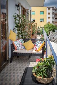 - un canapé sur un balcon avec des oreillers et des fleurs dans l'établissement Casa Rosetta, à Sorrente