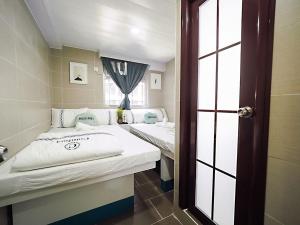 Habitación pequeña con 2 camas y ventana en HK International Hostel, en Hong Kong