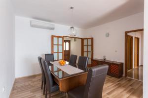 une salle à manger avec une table et des chaises noires dans l'établissement Apartment Sea to Sky Dubrovnik, à Dubrovnik