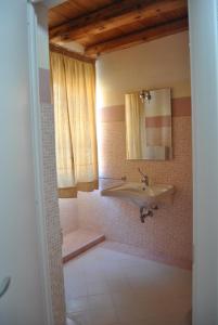 a bathroom with a sink and a mirror at Abas Ristorante Pizzeria Affittacamere in Ales