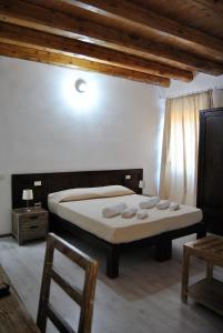 a bedroom with a bed and a table and a chair at Abas Ristorante Pizzeria Affittacamere in Ales