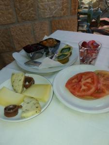 dos platos de comida en una mesa con queso y tomates en Posada Venero, en Cabárceno