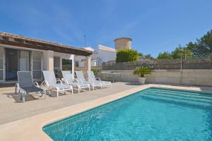 una piscina con sedie a sdraio e una casa di Rufo House a Alcudia