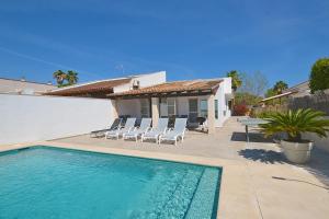 una piscina con sedie e una casa di Rufo House a Alcudia